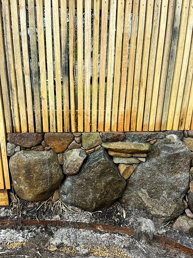 Boulder retaining wall with timber batten screen above