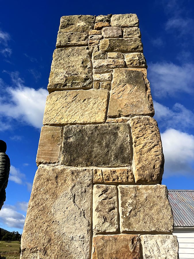 Sandstone chimney seen from below against blue sky