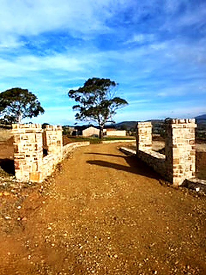 Stone entry pillars flanking a gravel driveway