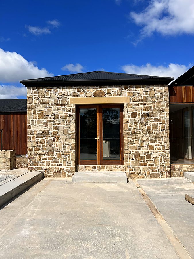 Stone entry with dressed sandstone lintel and timber doors