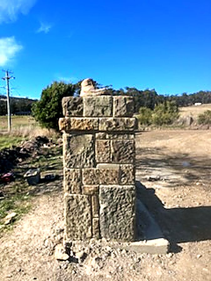 Capped stone pillar on a rural entrance