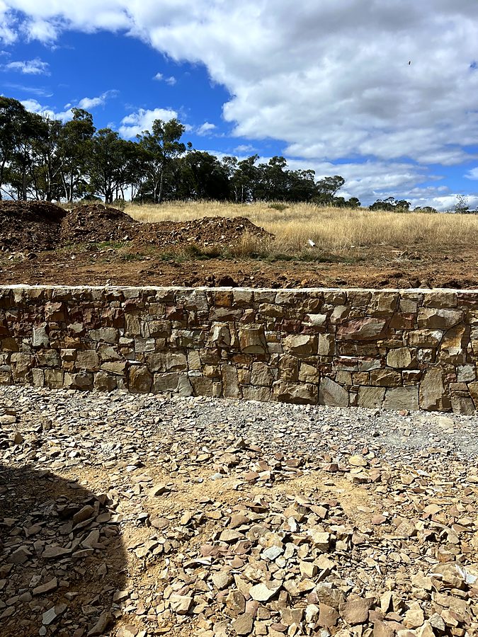 Capped stone retaining wall on a rural site