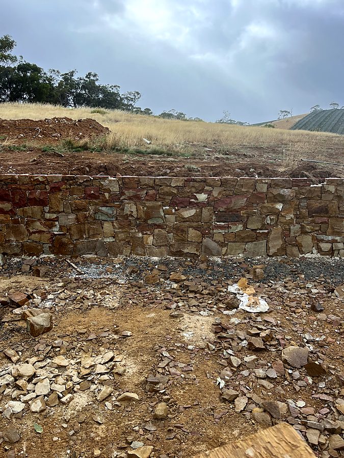 Rubble stone retaining wall under a stormy sky