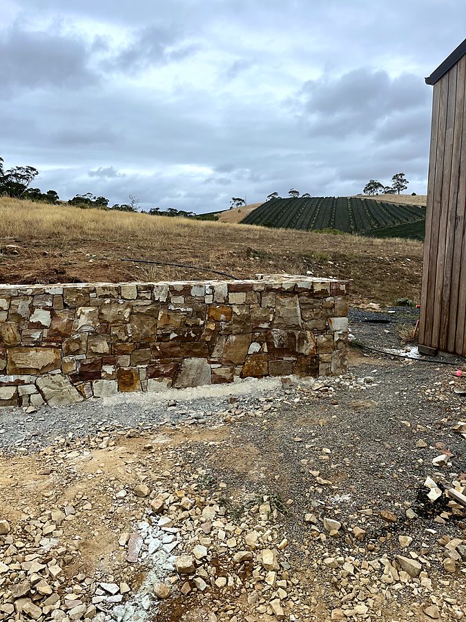 Stone retaining wall with vineyard beyond